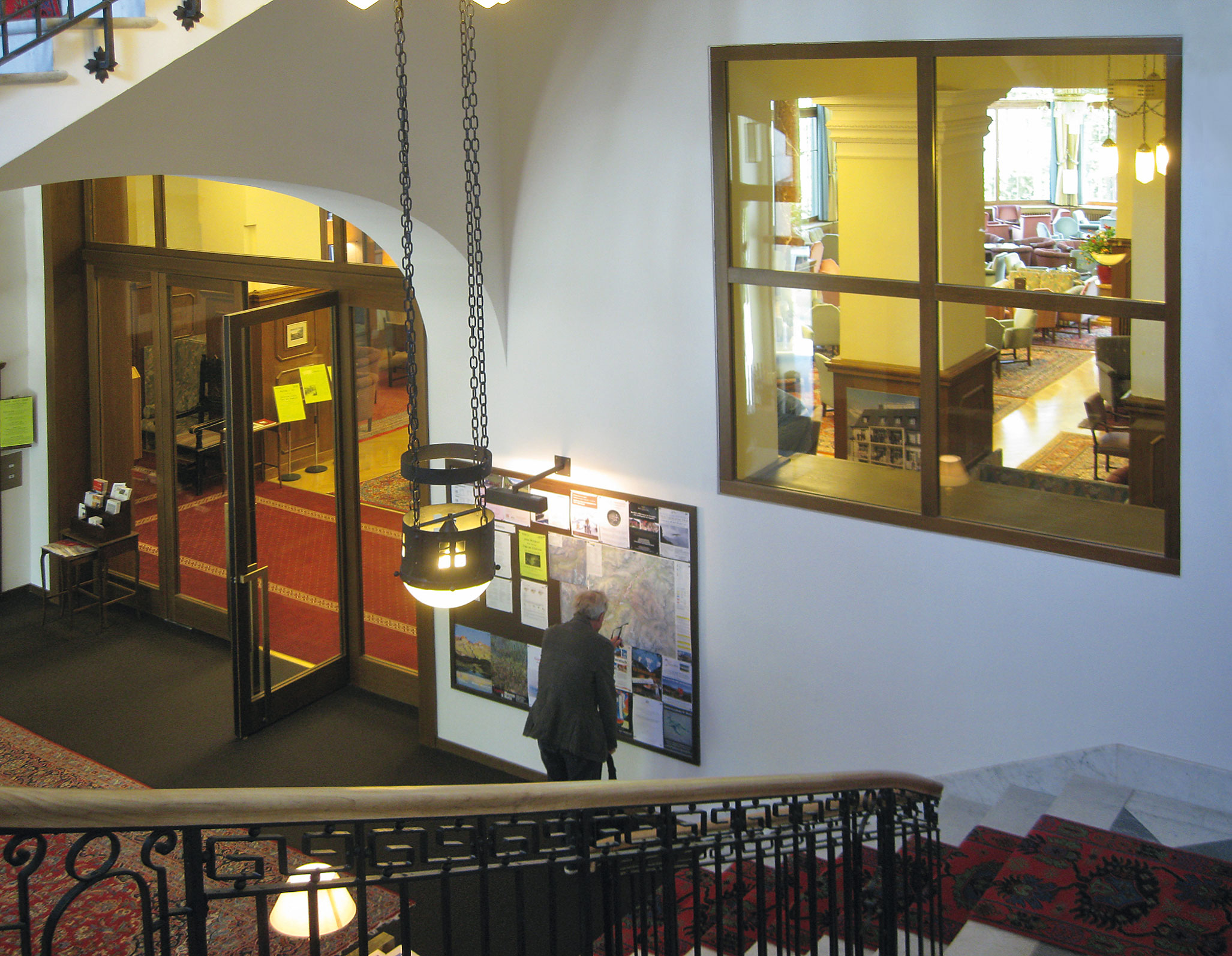 Continuité de l’espace et axes visuels dans l’hôtel Waldhaus Sils: vue depuis la cage d’escalier vers le hall d’entrée de l’hôtel.