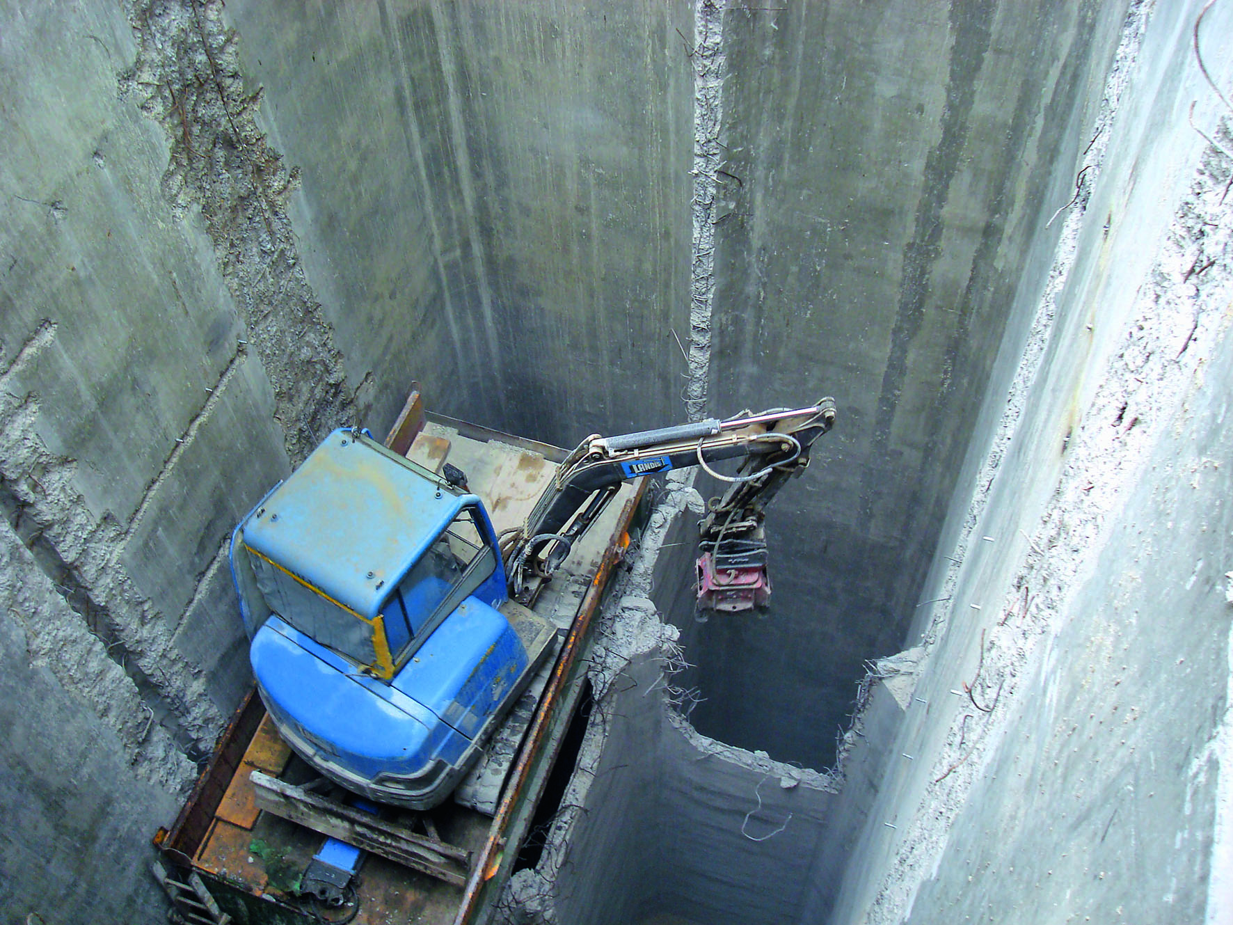 Das Foto zeigt den Bagger, der die Silowände in den Zellen rückbaute (Foto: Berchtold?+?Eicher)