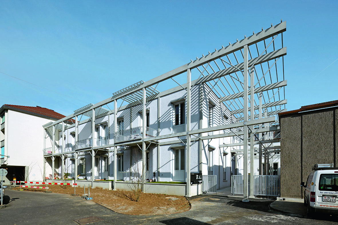 An der Fassade bildet ein Holzgerüst das Holzskelett des Tragwerks ab (Foto: Michael Fritschi)