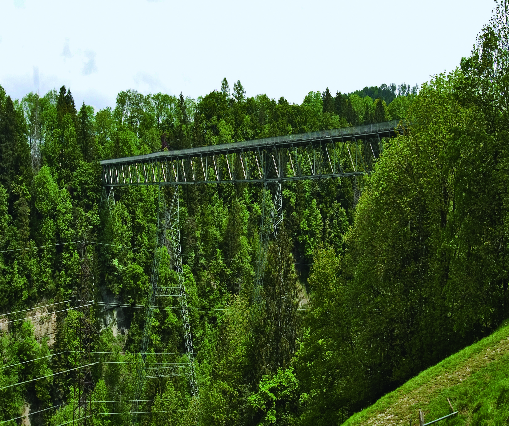 Filigranes Stahlfachwerk hier noch vor der Instandsetzung: Die Brückenkonstruktion ist ein Durchlaufträger, der 350?m lang und 4?m breit ist, wobei er zwei Ausweichstellen von 6?m Breite aufweist. Die maximale Spannweite beträgt 69.5 m in zwei Feldern
