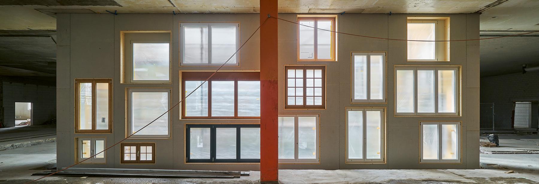 Die Fassade des Innenhofs im Basler Lysbüchel-Areal wurde vom Baubüro in situ mit Fenstern aus Über- oder Reservebeständen von rund zehn Schweizer Fensterbauern erstellt. Hätte man sie hier nicht verwendet, wären sie als Sperrgut entsorgt worden. Foto: Martin Zeller Die Fassade des Innenhofs im Basler Lysbüchel-Areal wurde vom Baubüro in situ mit Fenstern aus Über- oder Reservebeständen von rund zehn Schweizer Fensterbauern erstellt. Hätte man sie hier nicht verwendet, wären sie als Sperrgut entsorgt worden. Foto: Martin Zeller